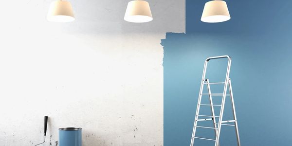 Half Painted wall with ladder and paint.