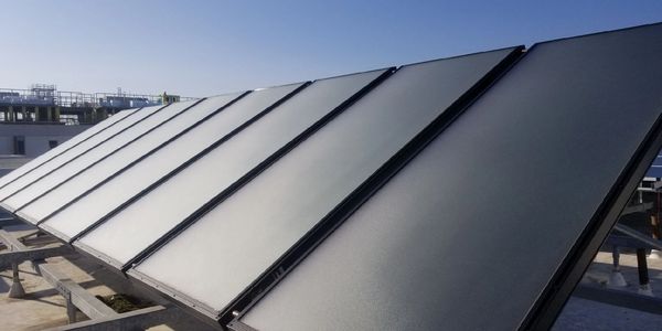 Solar panels installed on a rooftop under clear sky.