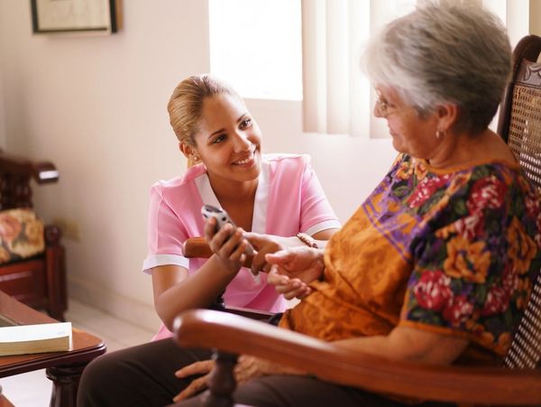Elderly in geriatric hospice: elderly lady with vision problems viewing mobile phone screen