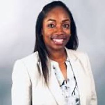Professional woman in a light blazer smiling at the camera.