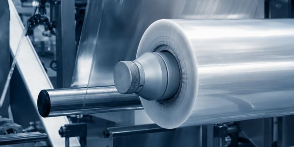 Rollo grande de lámina de plástico en una máquina industrial.