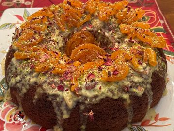 Eggless  cardamom flavored bundt cake topped with thick rabdi, pistachios, rose petals, and jalebi. 