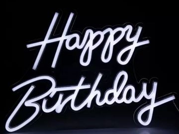 Neon sign glowing with the words 'Happy Birthday' in cursive.