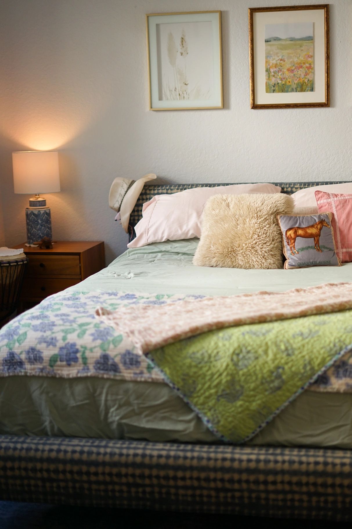 Cozy bedroom with a patterned bed, soft pillows, and warm lighting.