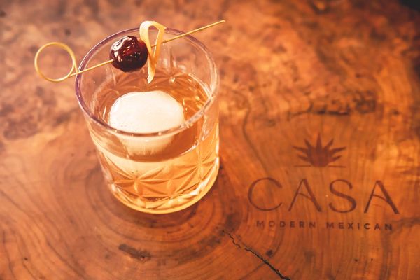 Old fashioned cocktail on a wooden table at Casa Modern Mexican.