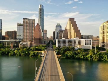Congress Avenue Bridge leading toward the downtown Austin skyline over Lady Bird Lake.