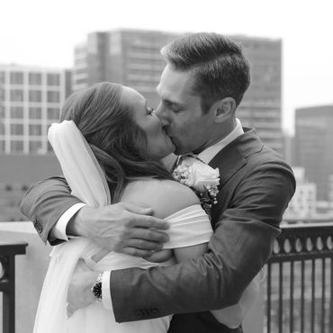 Bride and groom sharing a kiss outdoors.