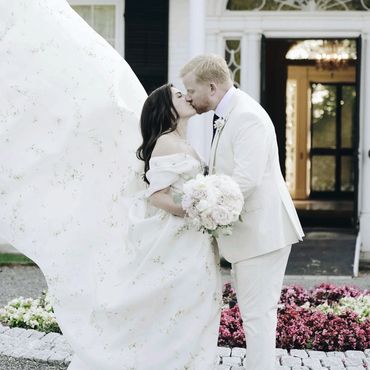 Bride and groom sharing a kiss outdoors.