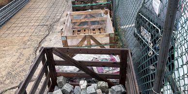 Crates filled with stone cubes on a sidewalk.