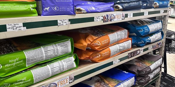 Pet food bags on store shelves.
