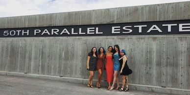a group of women standing in front of a cement wall