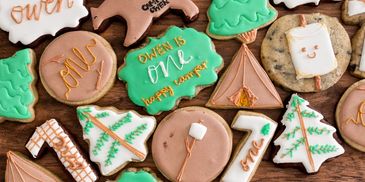 Decorated cookies celebrating a first birthday with camping theme.