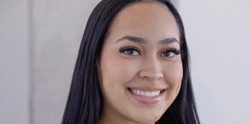 Smiling woman with long dark hair.