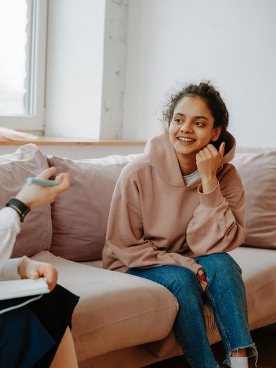 Two women engaged in a friendly conversation on a couch.