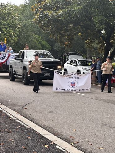 Veterans honored in a parade with a banner and participants marching.