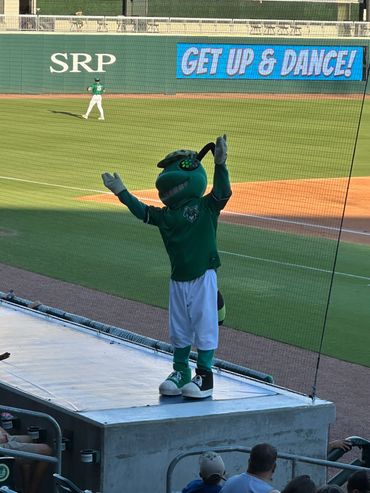 Baseball mascot dancing on platform at stadium