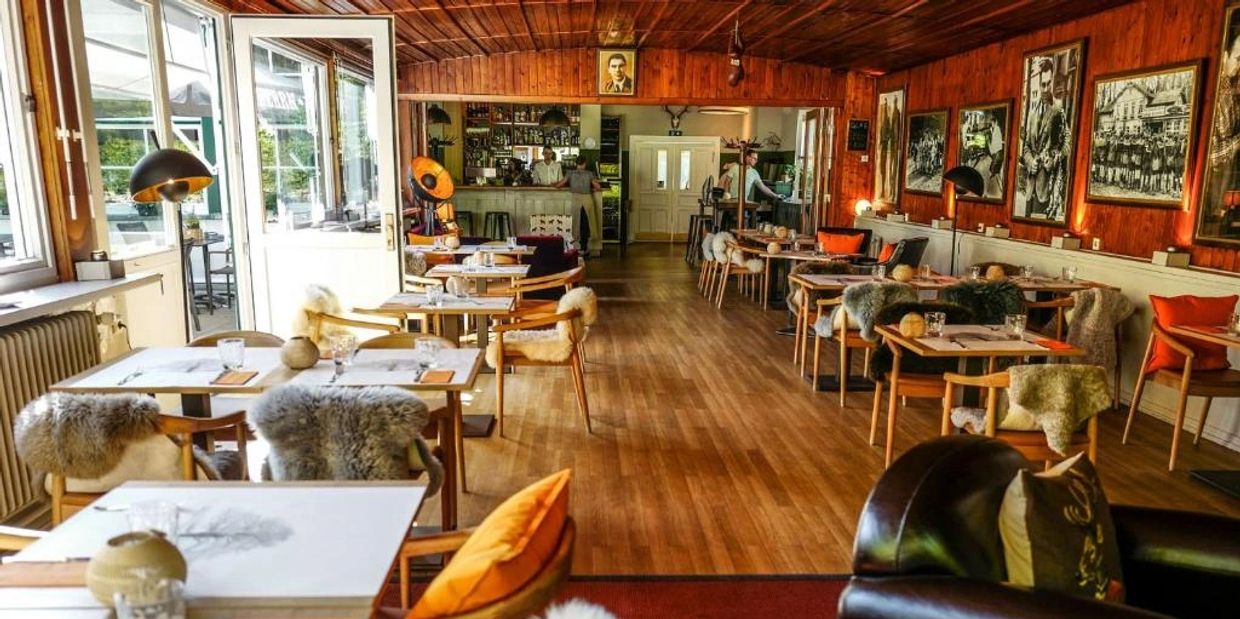 Cozy restaurant with wooden interiors and fur-covered chairs.