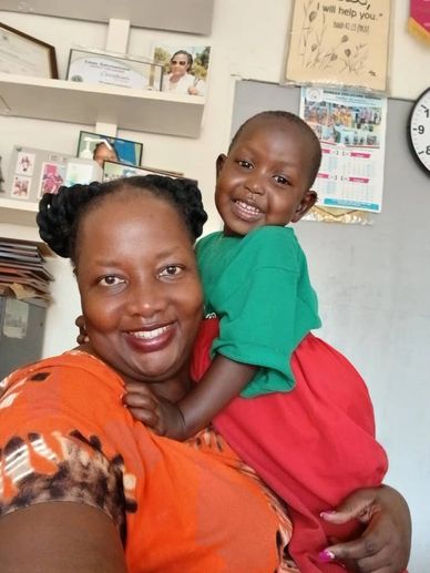 A joyful woman holds a smiling child in a cozy indoor setting.