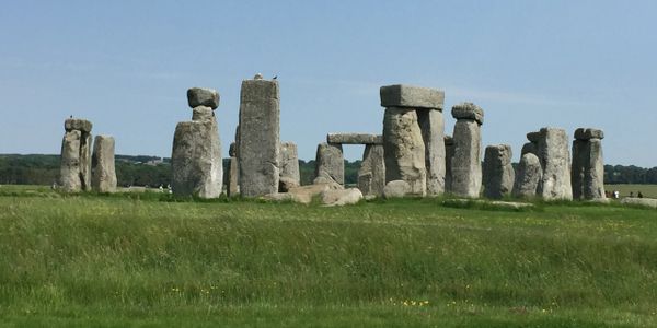 Stonehenge, a prehistoric monument with large standing stones under a clear sky.