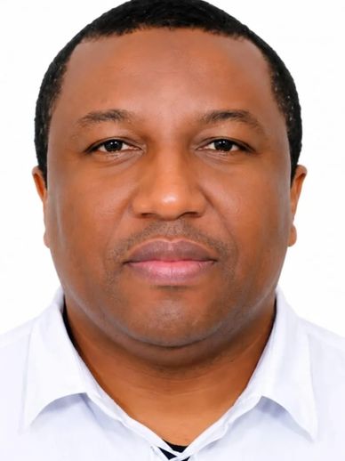 Portrait of a man in a white shirt with a neutral expression.
