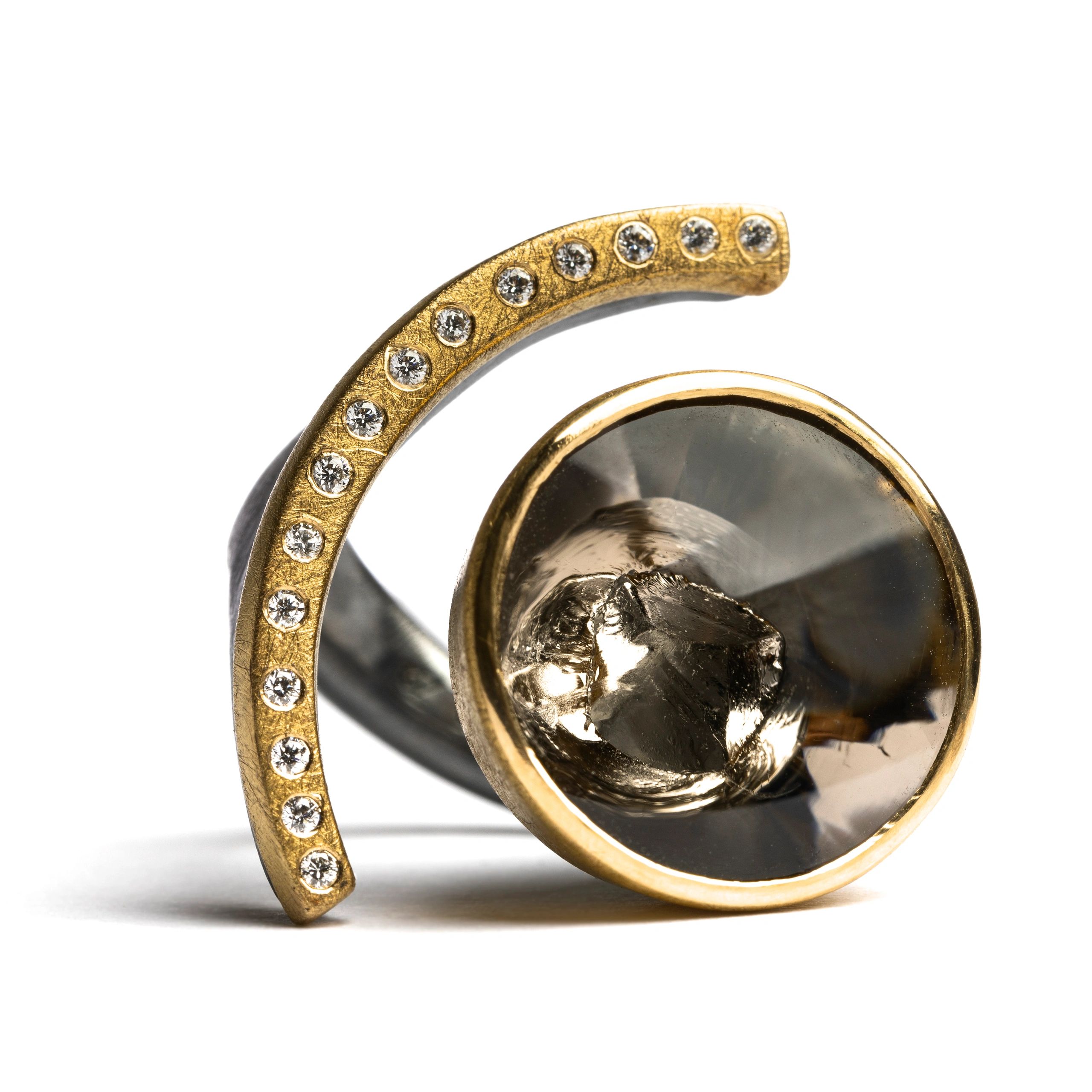 Close-up of a gold and diamond-encrusted ring with a unique design.