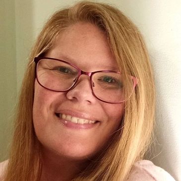 A smiling woman with long blonde hair and glasses.