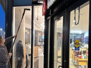 Aaron, the owner of The Upper Glass, doing storefront window cleaning in downtown Halifax.