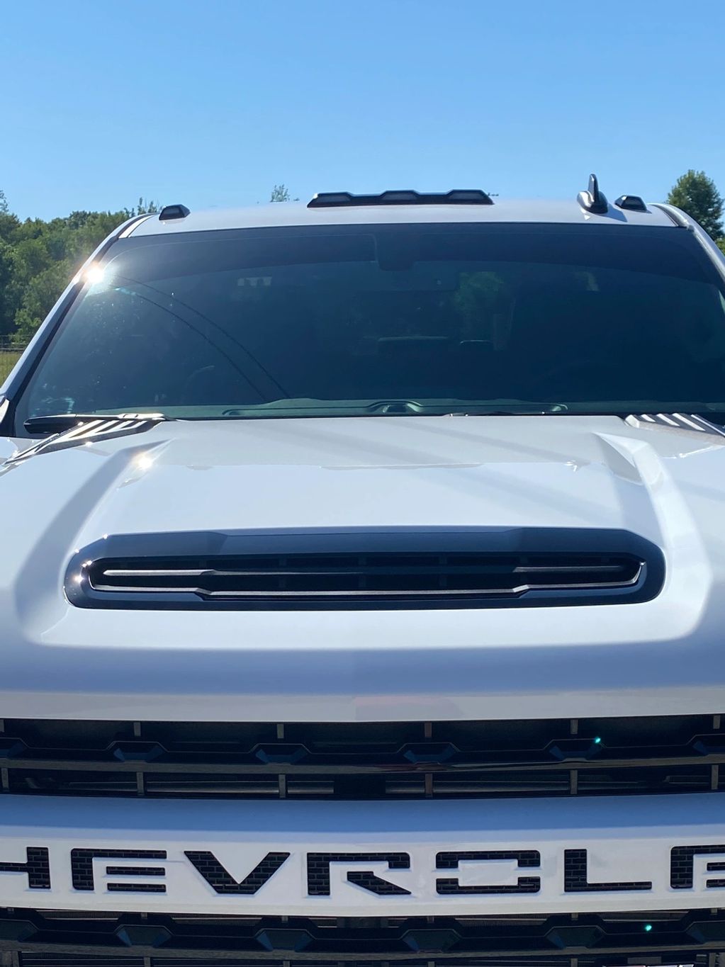 Front view of a white Chevrolet truck under clear skies.