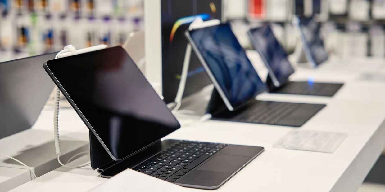 Row of tablets with keyboards on display in a store.
