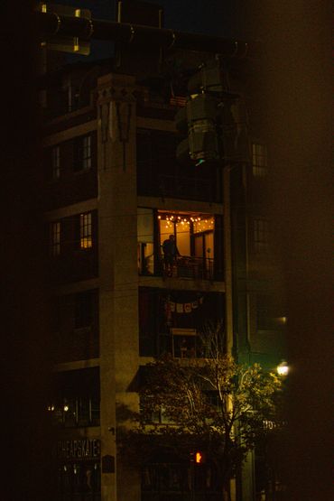 Dimly lit apartment with balcony lights glowing warmly at night.
