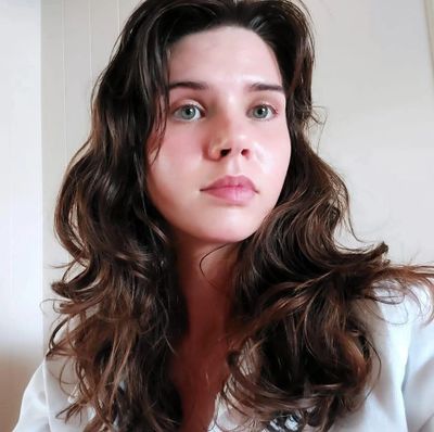 Young woman with long wavy hair looking slightly off camera.