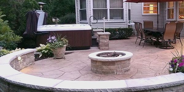 A cozy patio featuring a hot tub and fire pit, perfect for relaxing evenings outdoors.