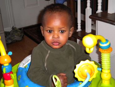 Pic 2.
Cute toddler standing in a muti-colored walker steering.