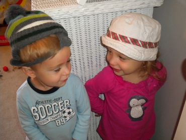 Pic 8
Boy with green knitted hat and girl wearing tan bucket hat gazing at each other.