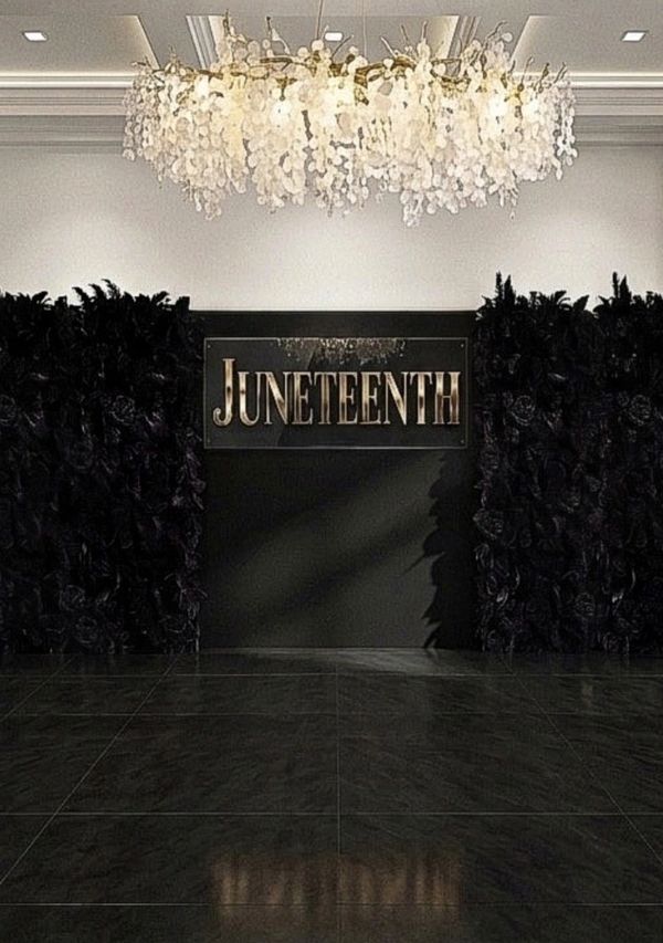 Elegant Juneteenth display with black floral walls and a chandelier.