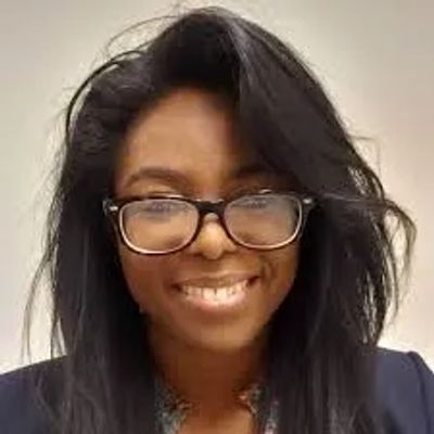Smiling woman with glasses and long black hair.