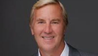 Smiling middle-aged man in a professional headshot against a dark background.