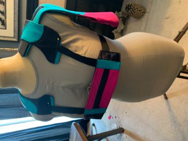 Colorful harness with pink and teal accents on a mannequin.