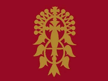 Golden traditional Ethiopian cross on a red background.