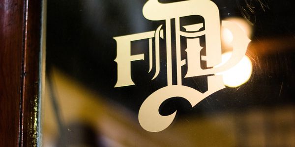 Stylized vintage lettering on a reflective glass surface.