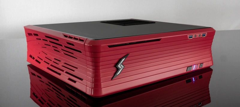 Sleek red and black compact PC case with ventilation slots and USB ports.