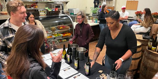 People enjoying a wine tasting event indoors with various wines on display.
