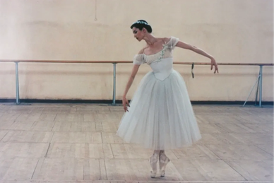Bolshoi ballerina poses on pointe in a dance studio