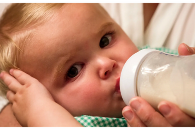 A baby drinks out of a bottle