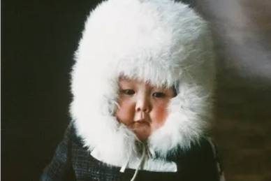 Child of the Russian tundra bundled in a white fur hood