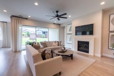Modern living room with beige sofas and a fireplace.