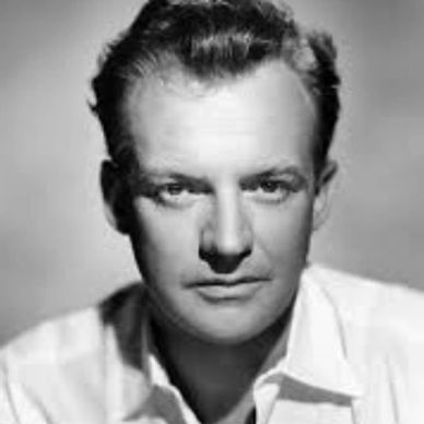 Black and white portrait of a serious man with slicked-back hair.