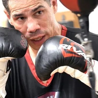 Boxer training with gloves focused on a punching bag.