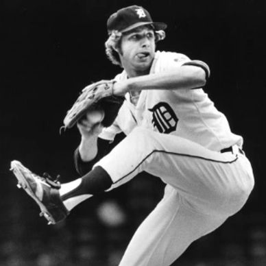 Black and white photo of a Detroit Tigers pitcher mid-pitch.