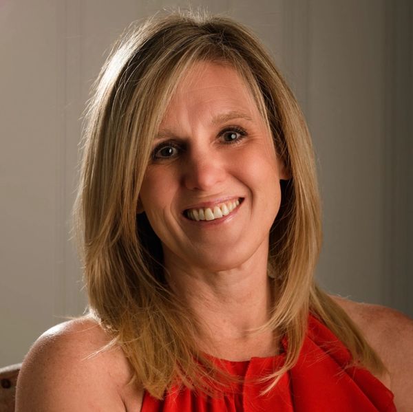 Smiling woman with blonde hair in red top.